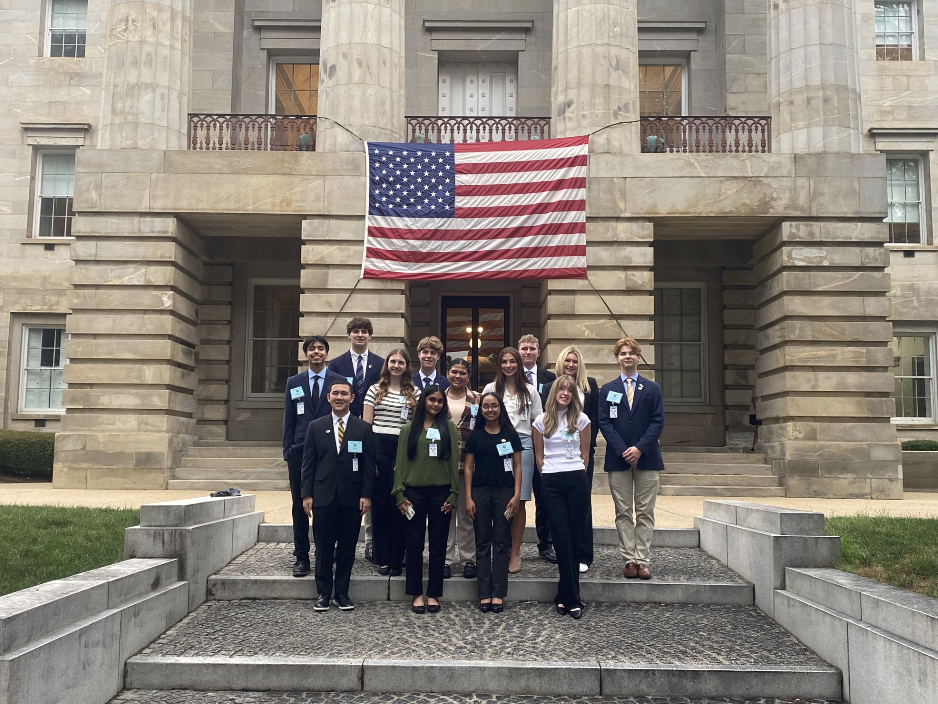 A group of pages standing on the steps in front of the NC State Capitol building.